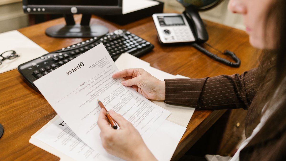 Amnesty Lawyer Slams ₦100m Defamation Ruling Against SERAP A lawyer examines divorce documents at a desk in a law office setting, emphasizing professionalism.