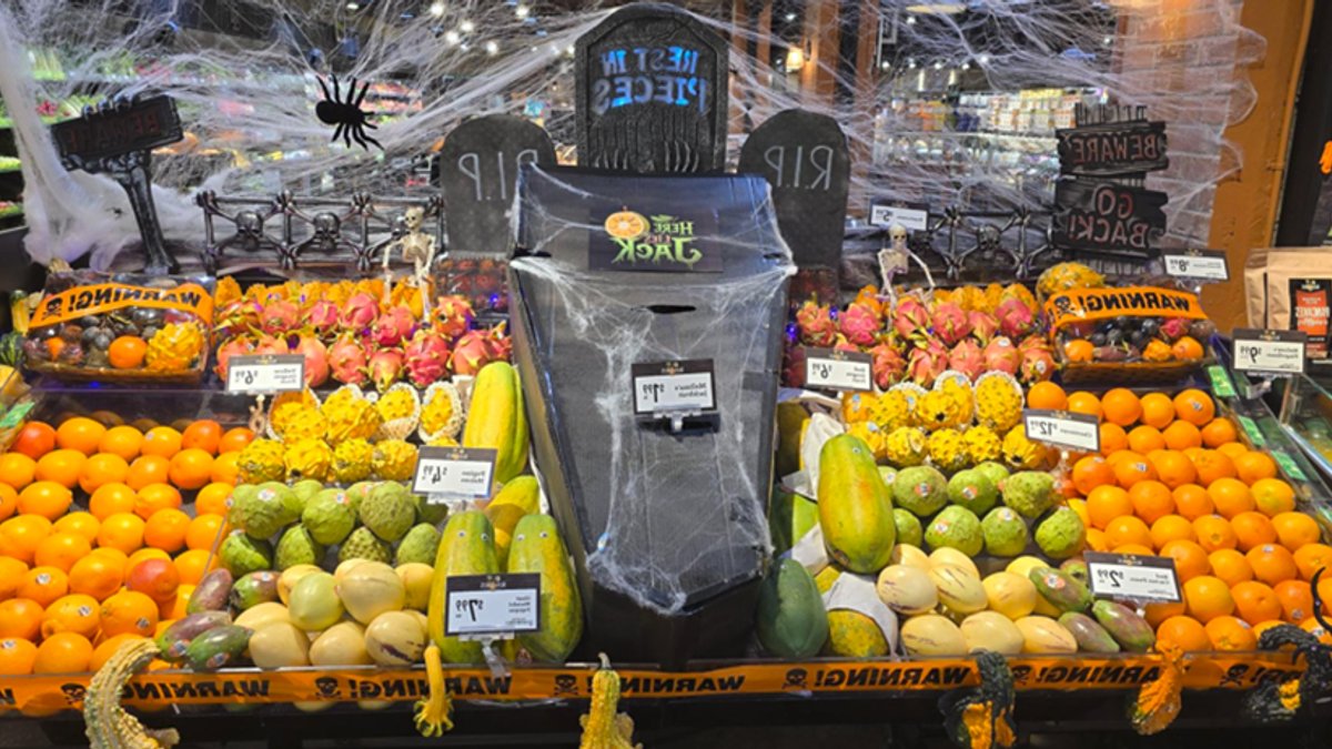 Halloween produce display featuring spider webs and coffin.