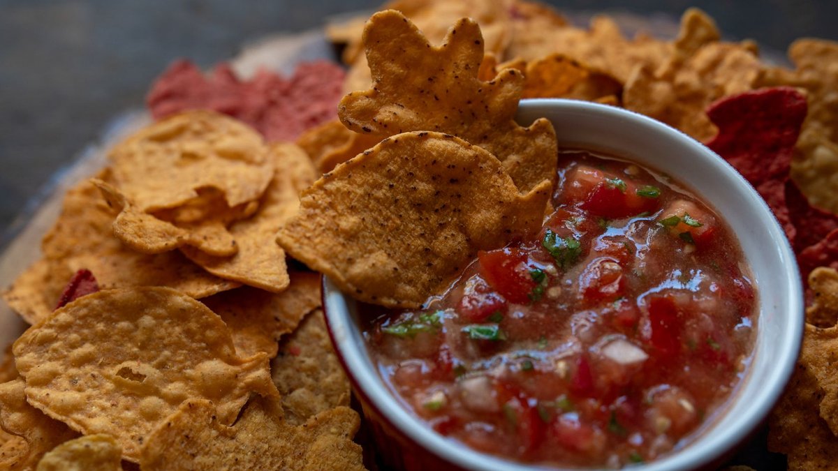 Close-up of tortilla chips with salsa, a perfect snack for gatherings.