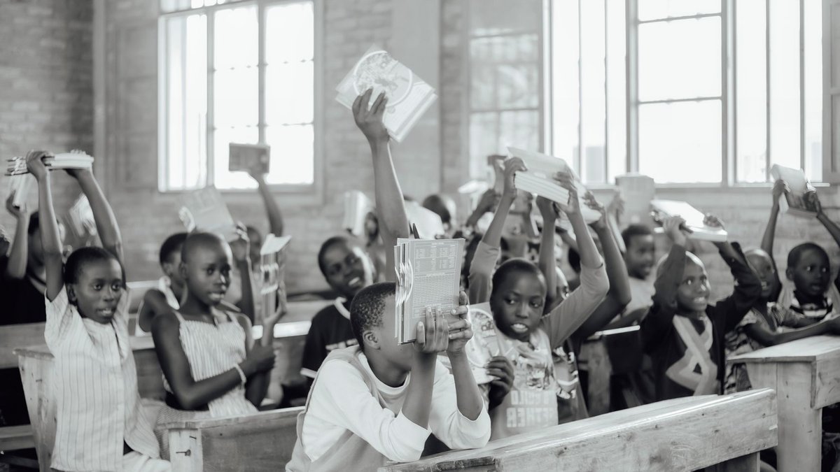 A lively classroom scene with students holding up books, creating an energetic and educational atmosphere.