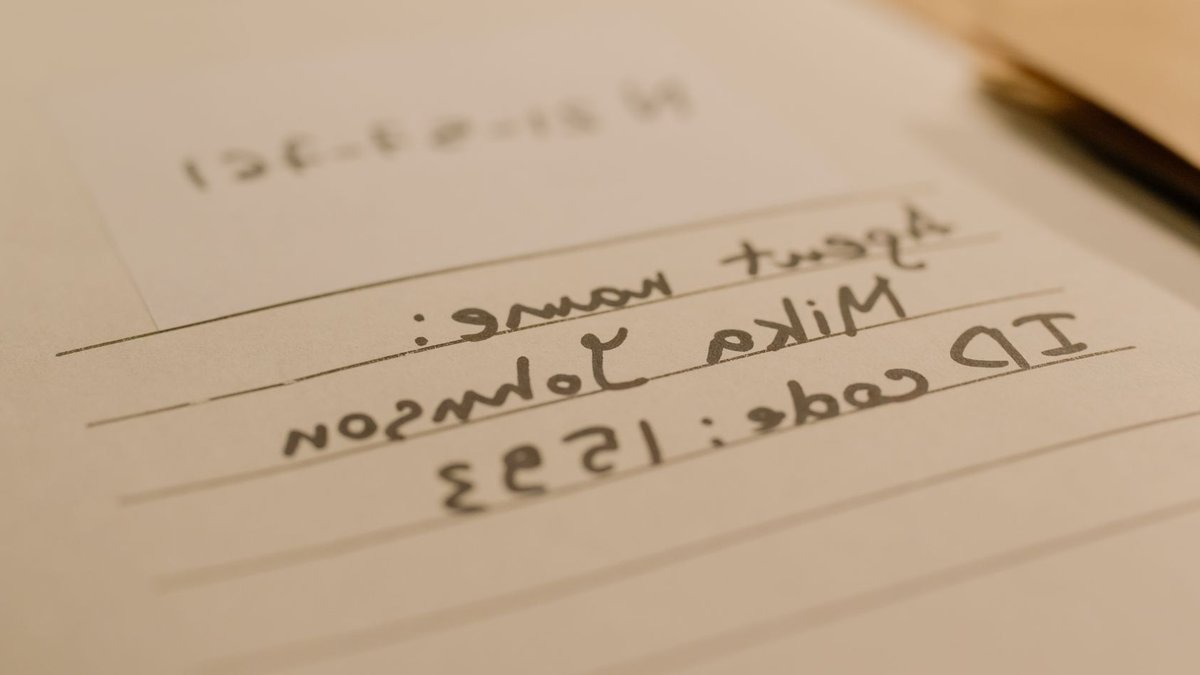 Handwritten document with agent name and ID code, showcasing personal handwritten text.
