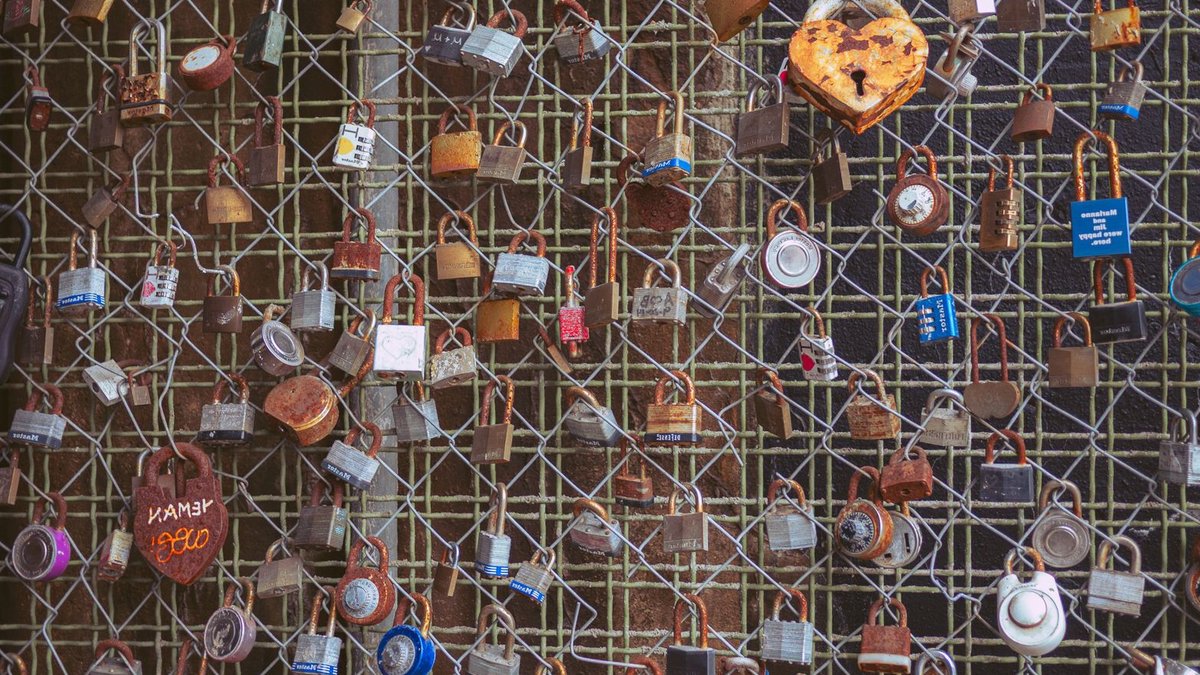 A collection of love locks on a fence, symbolizing everlasting bond and romance.