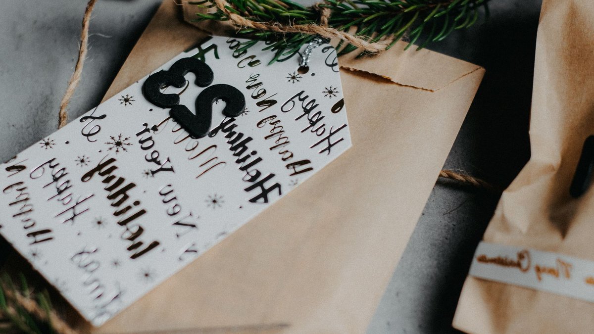 Close-up of a wrapped gift with an advent calendar tag and festive decorations.