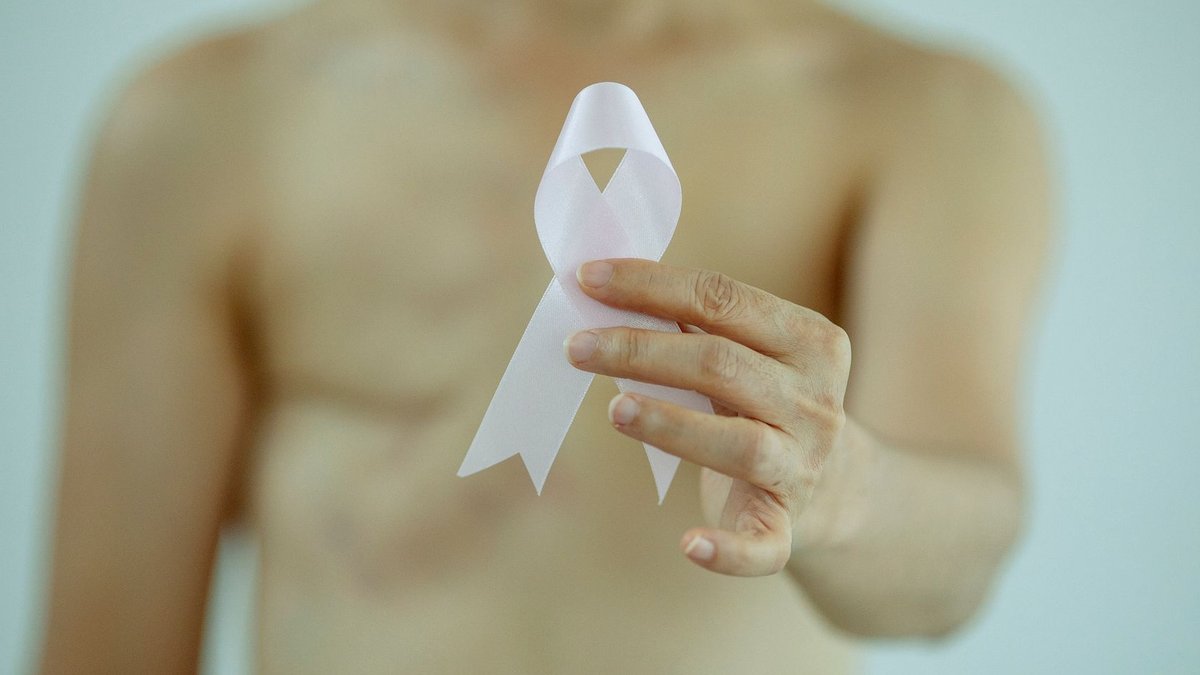Breast cancer treatment becomes more personalized Crop faceless topless lady with pink ribbon in hand with scar on chest after breast removal surgery from cancer standing in b