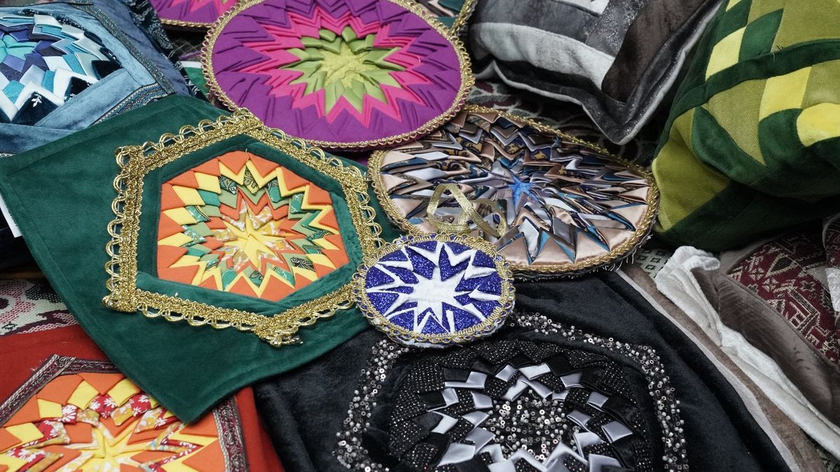 A vibrant collection of decorative pillows featuring intricate geometric quilt designs in various colors.