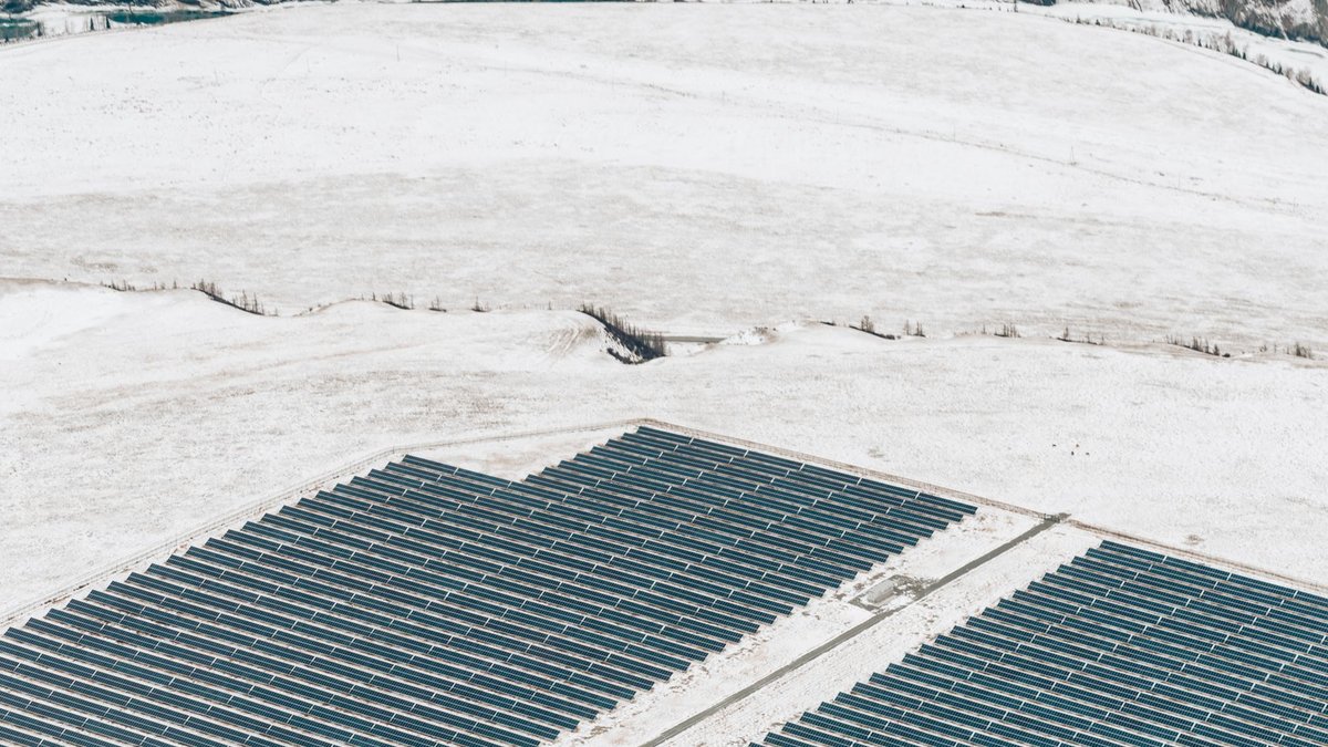 Equinor Warns Blocking Projects Jeopardizes UK Investment Aerial view of solar panels in a snowy winter landscape, showcasing green energy.