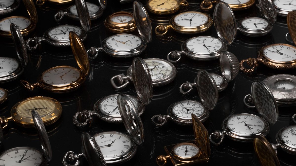 Rolex Daytonas Fetch £37.3M, Cartier Sets Record An exquisite display of various vintage pocket watches with intricate designs and metallic finishes.