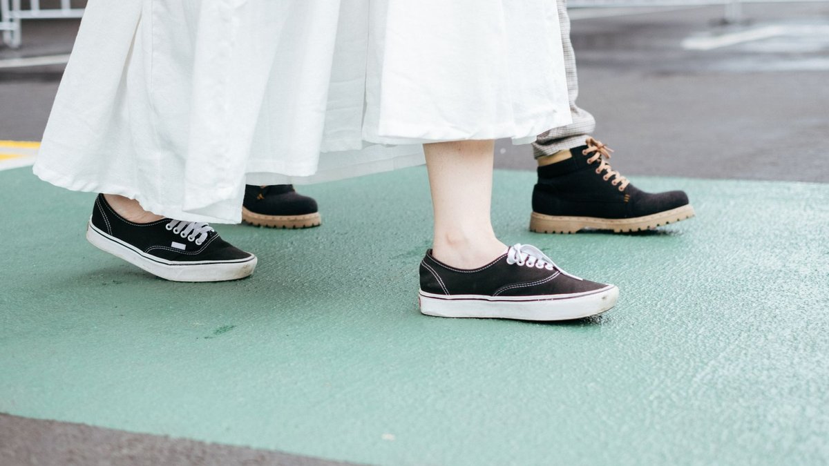 Clarks targets walking shoe mismatch with new tech campaign Low-angle view of people walking on a city street, capturing stylish footwear in motion.