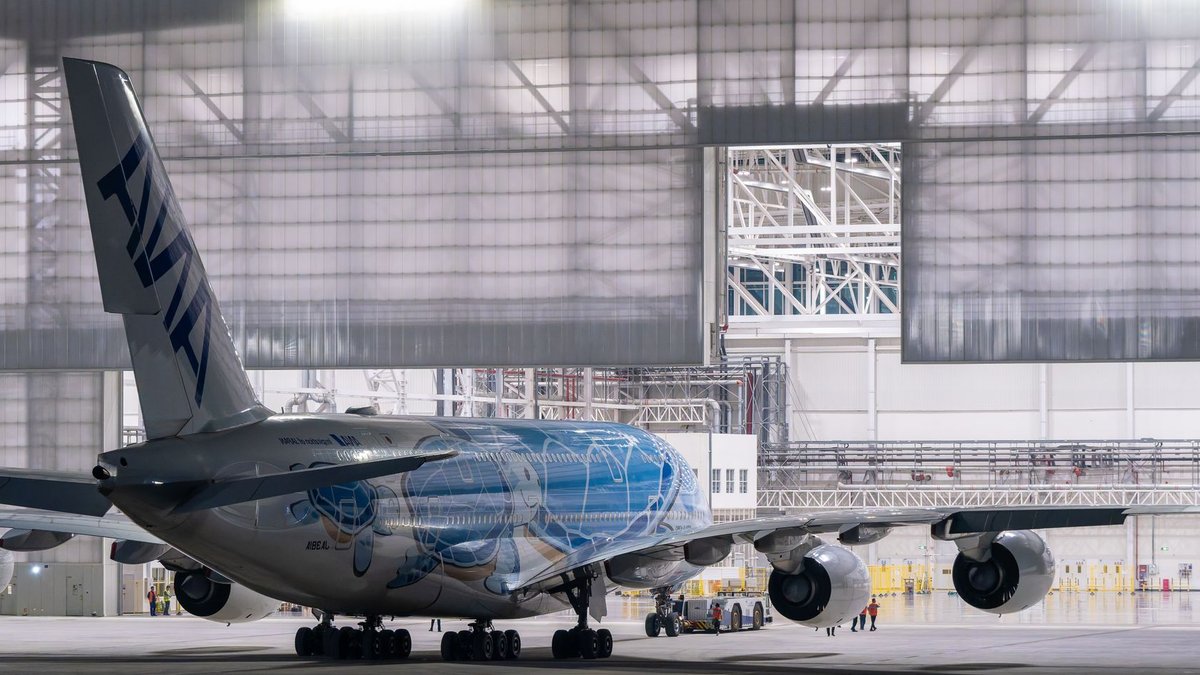 Ryanair threatens to move 300 jobs abroad Large commercial airplane in a hangar at night with open doors showcasing the aircraft.