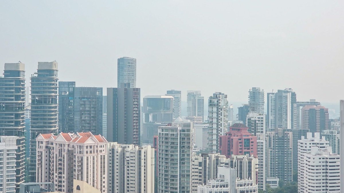 Singapore Property Investment Sales Hit Record High High-rise residential and commercial buildings forming a cityscape under a pale sky.