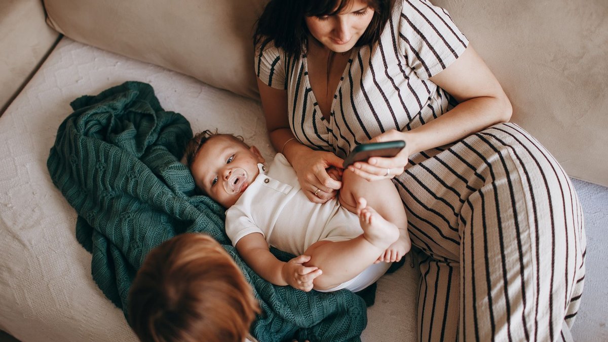 Widow fears care costs after husband excludes her from will A mother relaxes with her two children on a cozy sofa, creating a warm family moment.