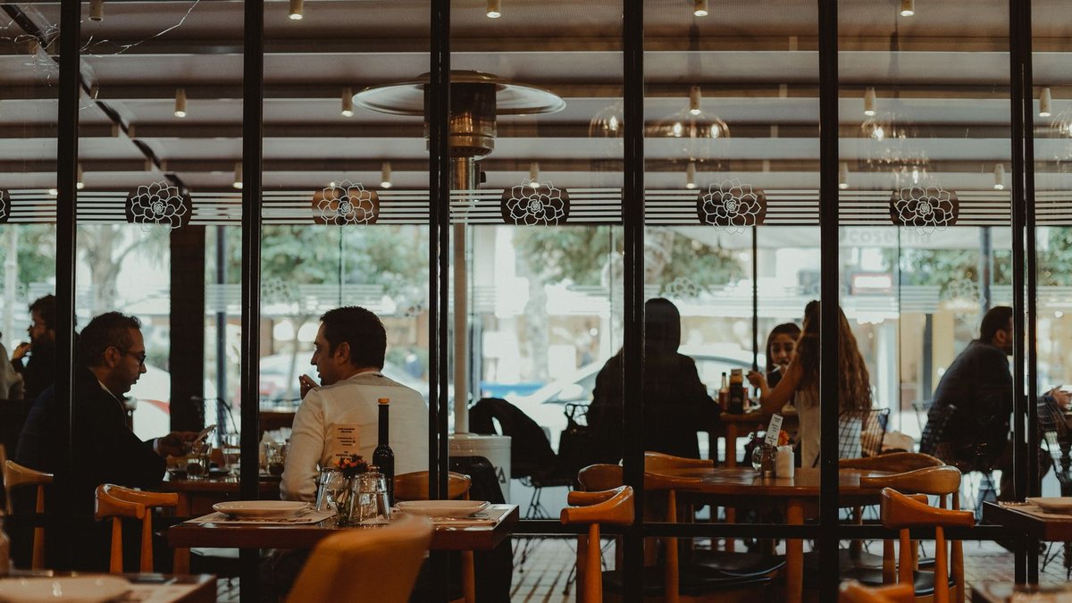 Restaurant Chains Hit Growth Milestones This Fall A bustling restaurant interior showcasing diners enjoying their meals in a cozy atmosphere.