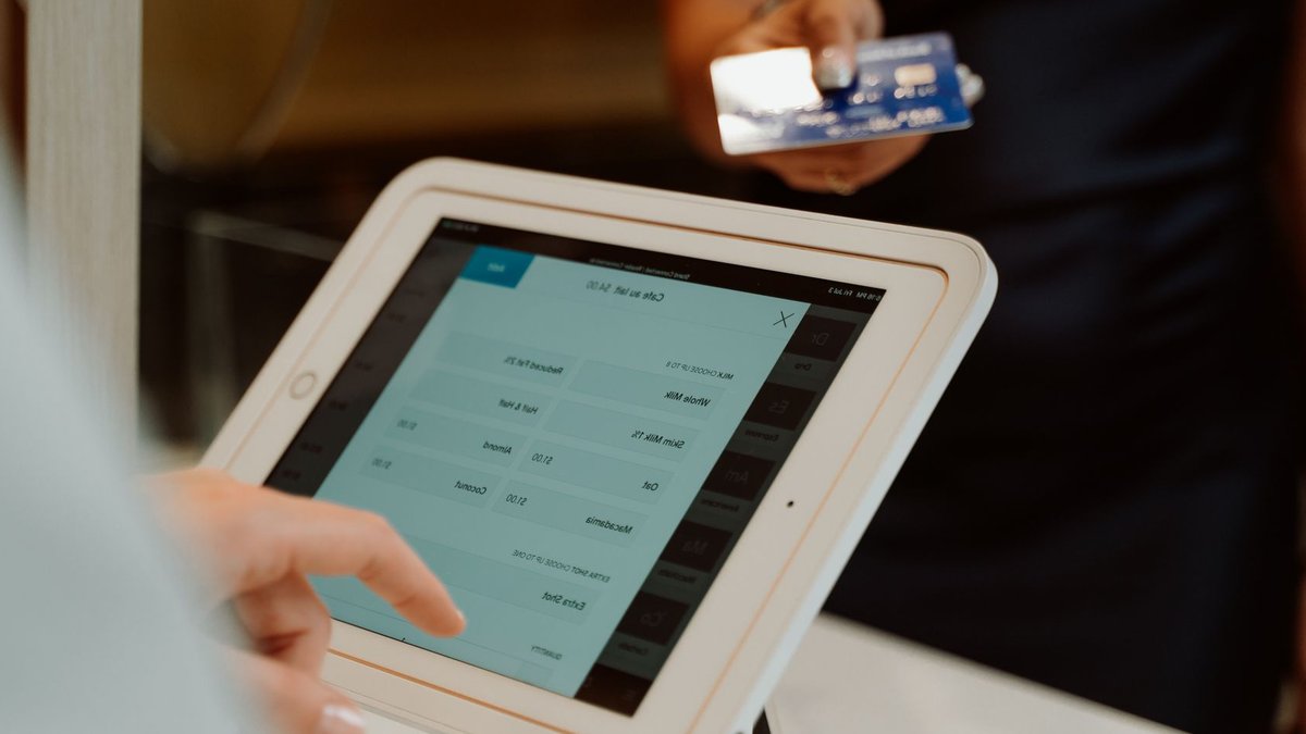 AmEx Unveils Framework to Authenticate AI Commerce A modern cashless payment system using a tablet and card for seamless transactions.
