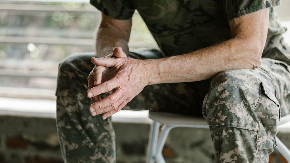 Close-up of a military veteran's hands in a therapy session, emphasizing mental health support.