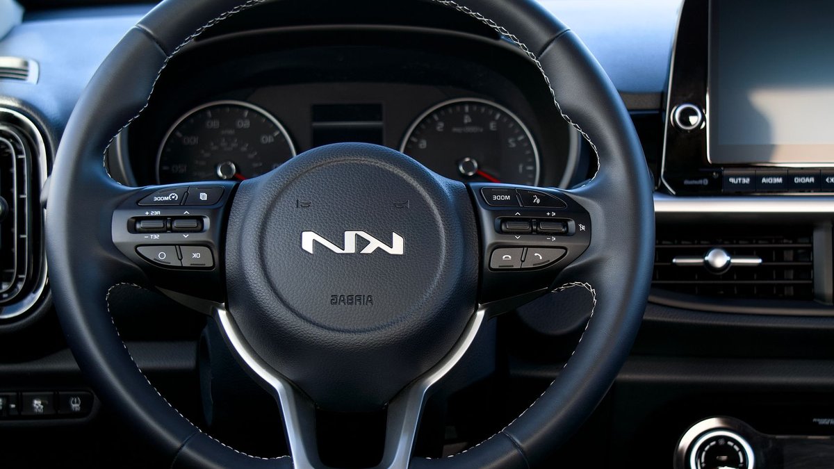 Kia Sonet Redesign Spotted: Sharper Look, Tech Upgrades Close-up of a Kia steering wheel and dashboard showcasing modern car interior design.
