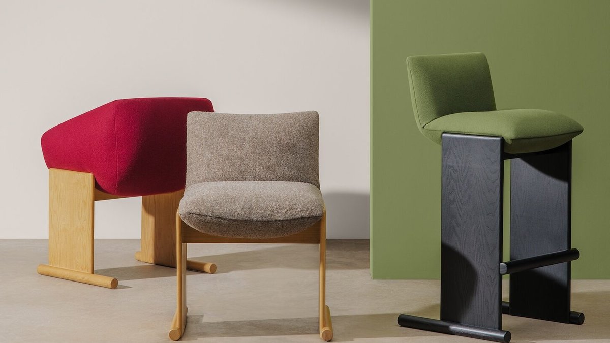 Urquiola redefines office design with cozy, flexible furniture Three Patin chairs — green, beige, and red — designed by Patricia Urquiola stand on a light floor against green and beige bac