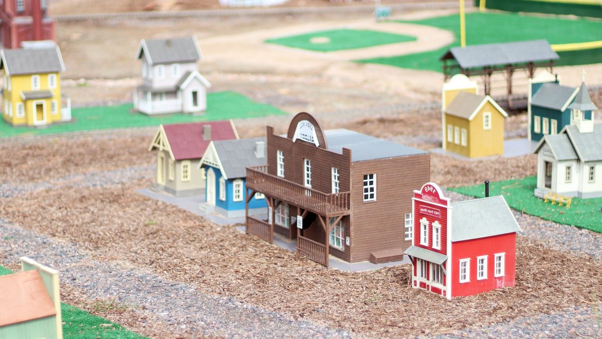 Holiday Magic: Lemax Adoption Center Setup Tips A detailed, colorful model town display depicting small houses and structures in a miniature setting.