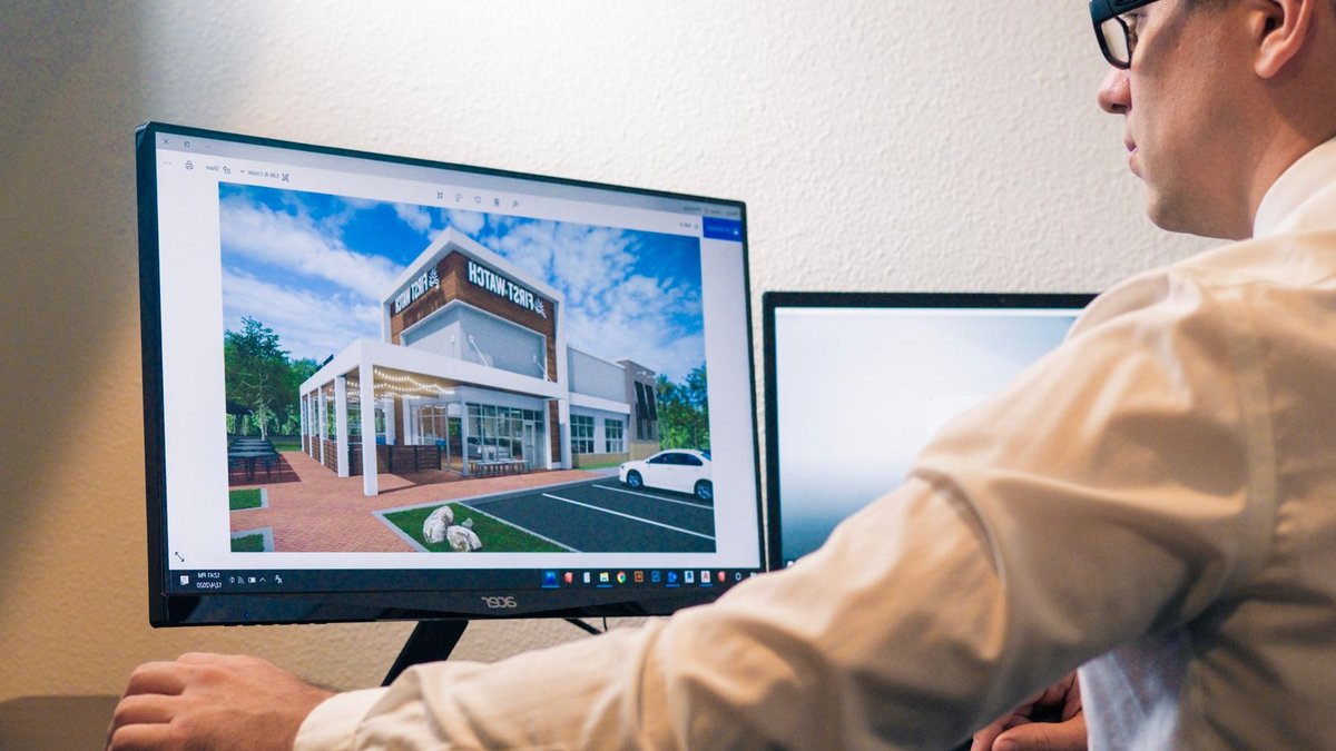 Architect evaluating a building design on a computer screen in an office setting.