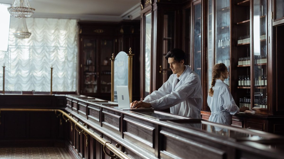 Pharmacists working in a vintage pharmacy setting with old-fashioned decor.