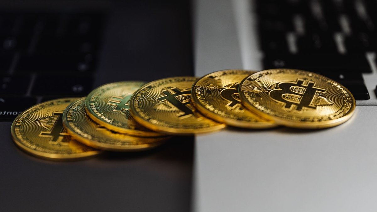 Digital gold market poised for massive growth A stack of gold bitcoin coins placed on a laptop keyboard, symbolizing digital currency and finance.