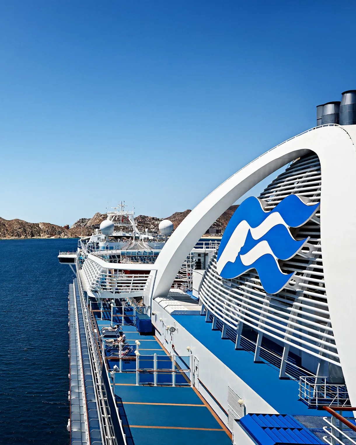 A striking side view of the Ruby Princess cruise ship docked in crystal-clear blue waters near Los