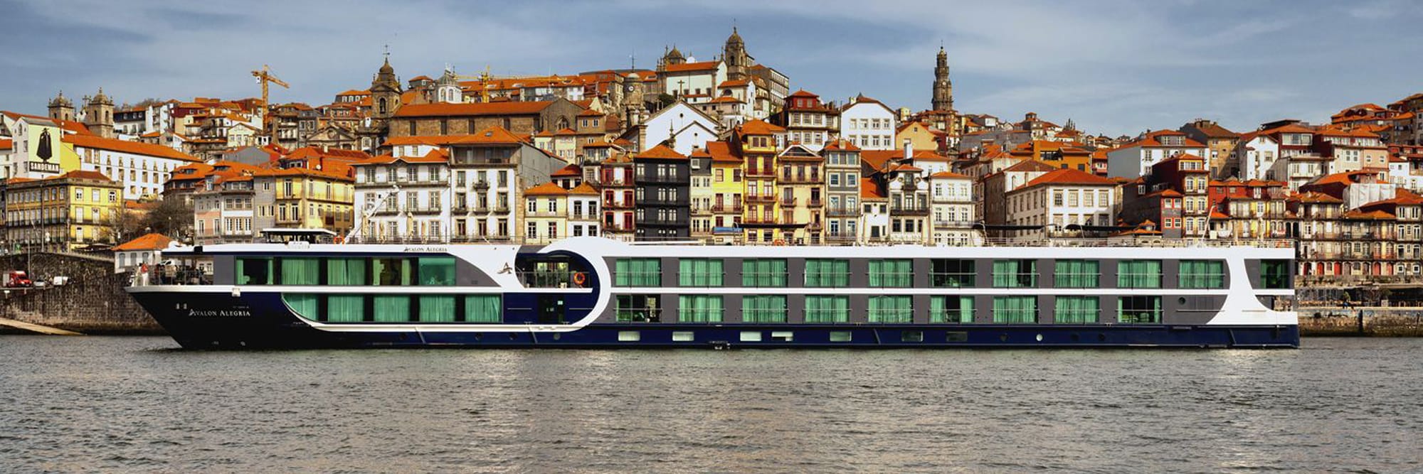 The Avalon Alegria, a modern river cruise ship with distinctive green-windowed upper decks