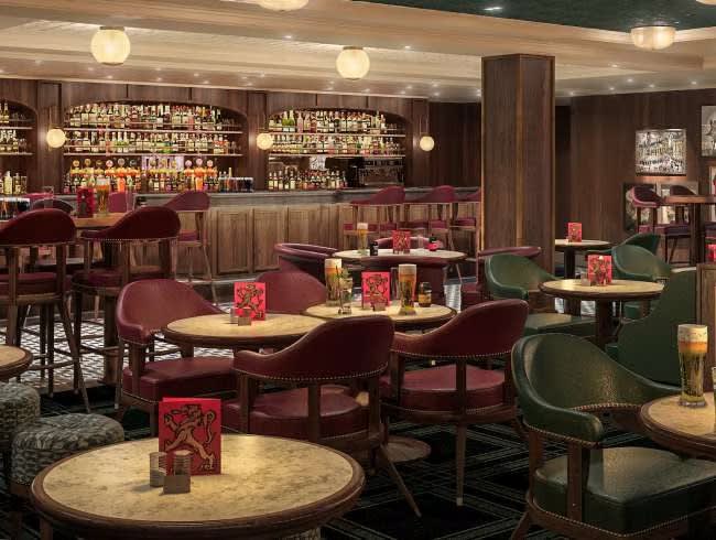 An elegant and luxurious bar lounge aboard Cunard's Queen Anne, featuring rich burgundy velvet