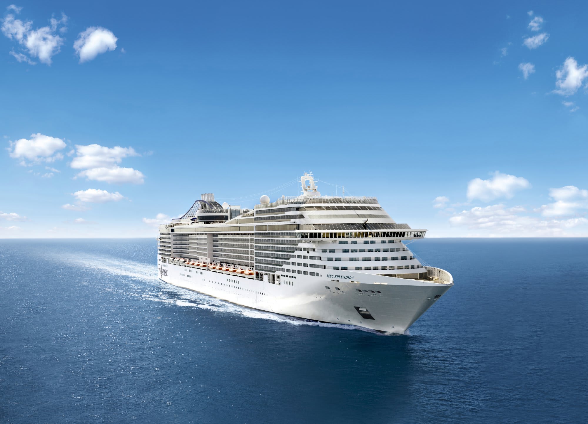 A modern luxury cruise ship sailing across calm blue waters under a partly cloudy sky. The large