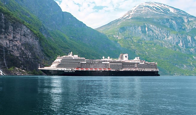 A modern cruise ship sailing through a stunning fjord with steep green mountainsides