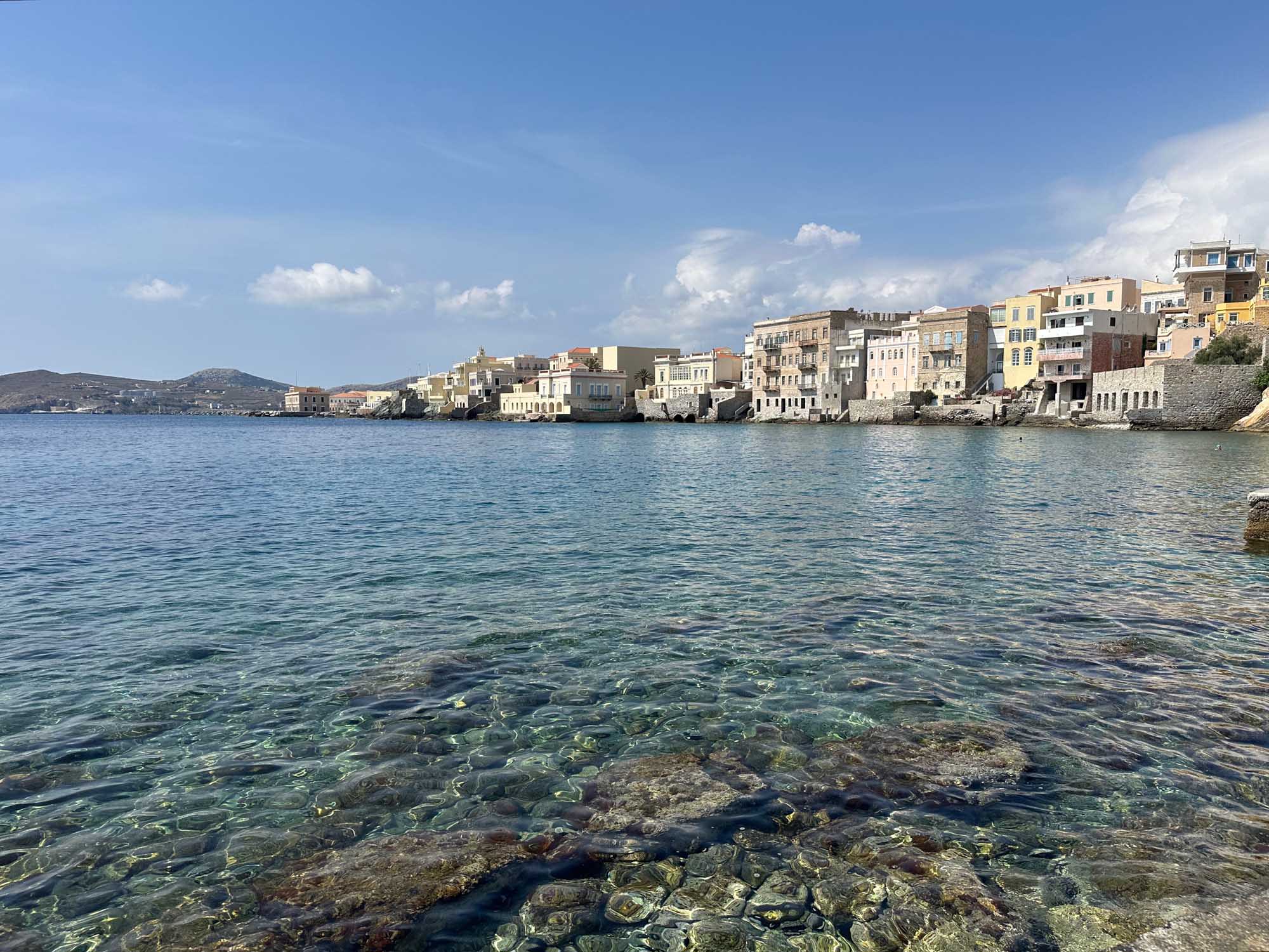 A picturesque Mediterranean coastal village with vibrant pastel-colored buildings cascading down