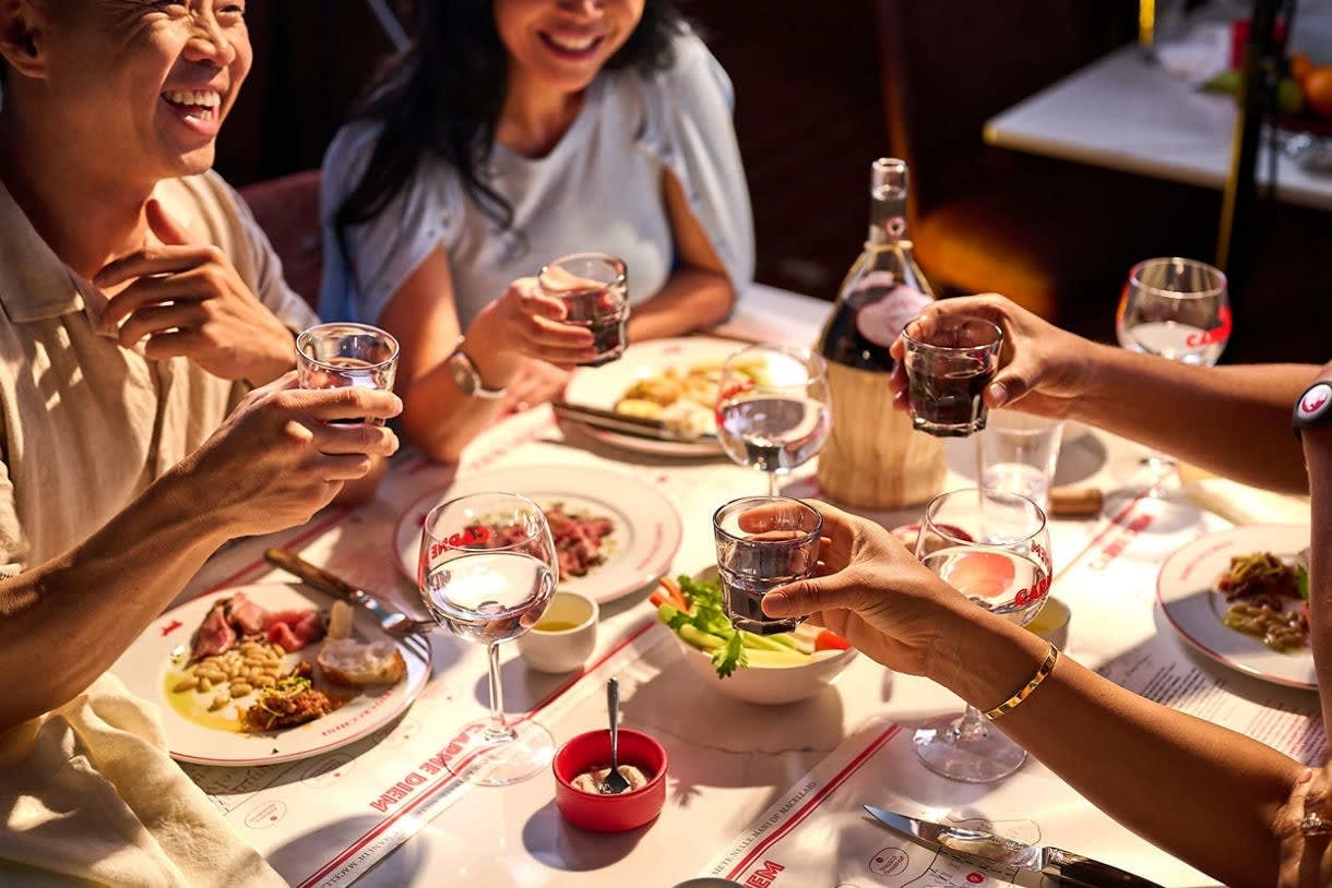 A group of passengers enjoying an elegant dinner gathering around a white-clothed table