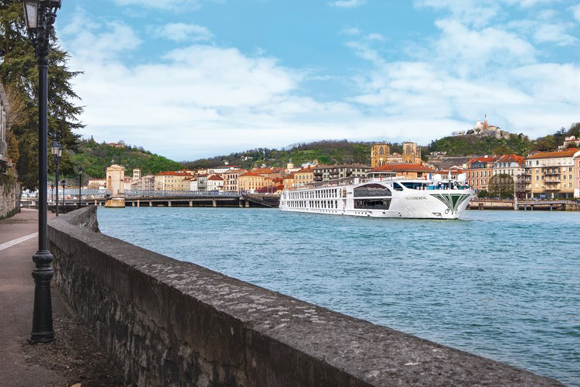 A modern white river cruise ship is moored in a picturesque European waterway lined with historic