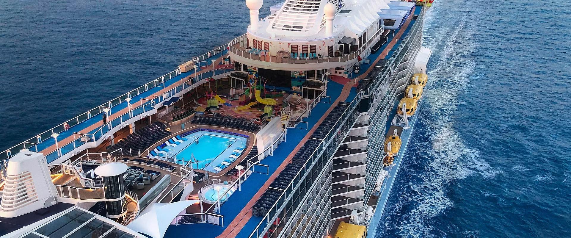 An aerial view of the Spectrum of the Seas cruise ship showing its expansive pool deck with bright