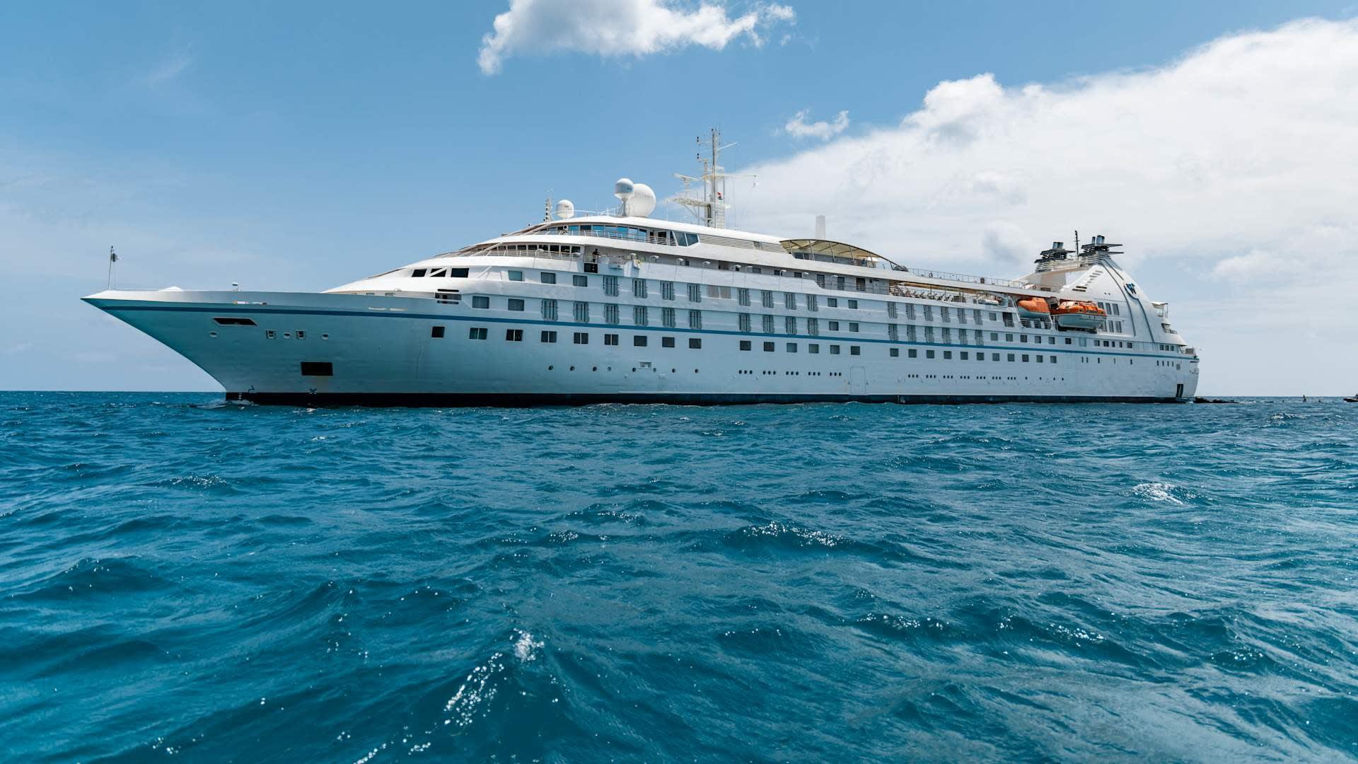 A luxurious small-ship cruise vessel, the Star Legend, anchored in calm turquoise Caribbean waters