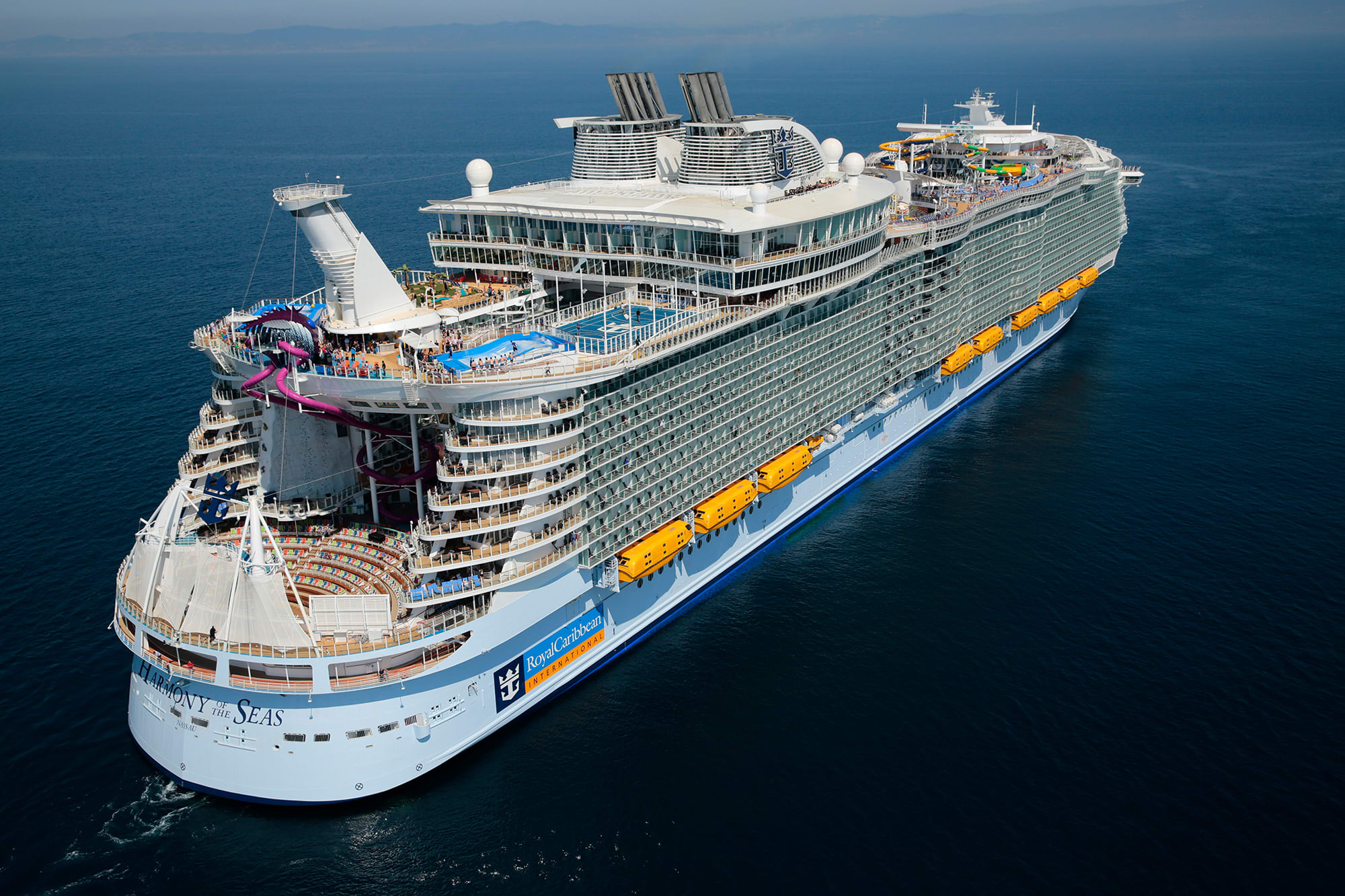 An aerial photograph of the Harmony of the Seas, a massive modern cruise ship, positioned offshore