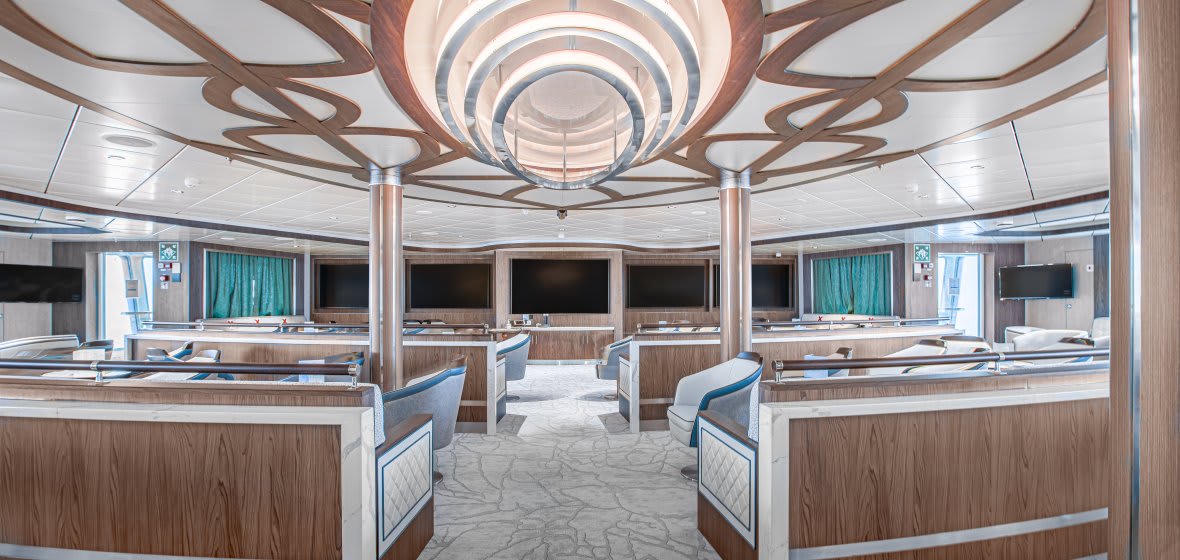 A sophisticated lecture room or auditorium featuring a striking circular tiered ceiling with wood