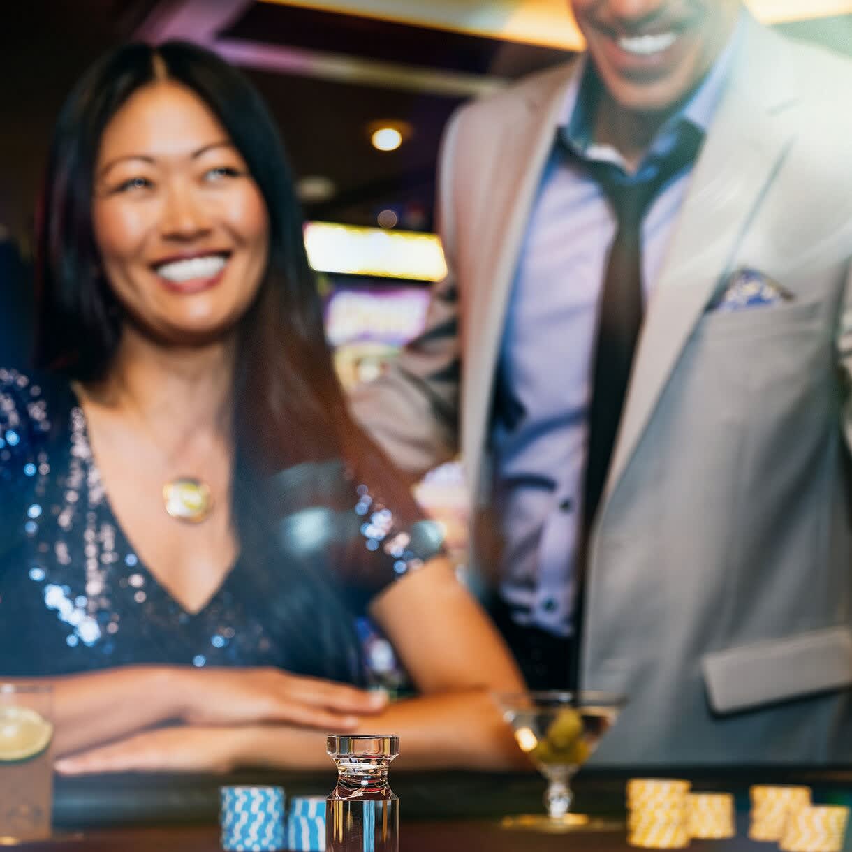 A well-dressed couple smiles at a casino roulette table aboard a Princess Cruises ship, with