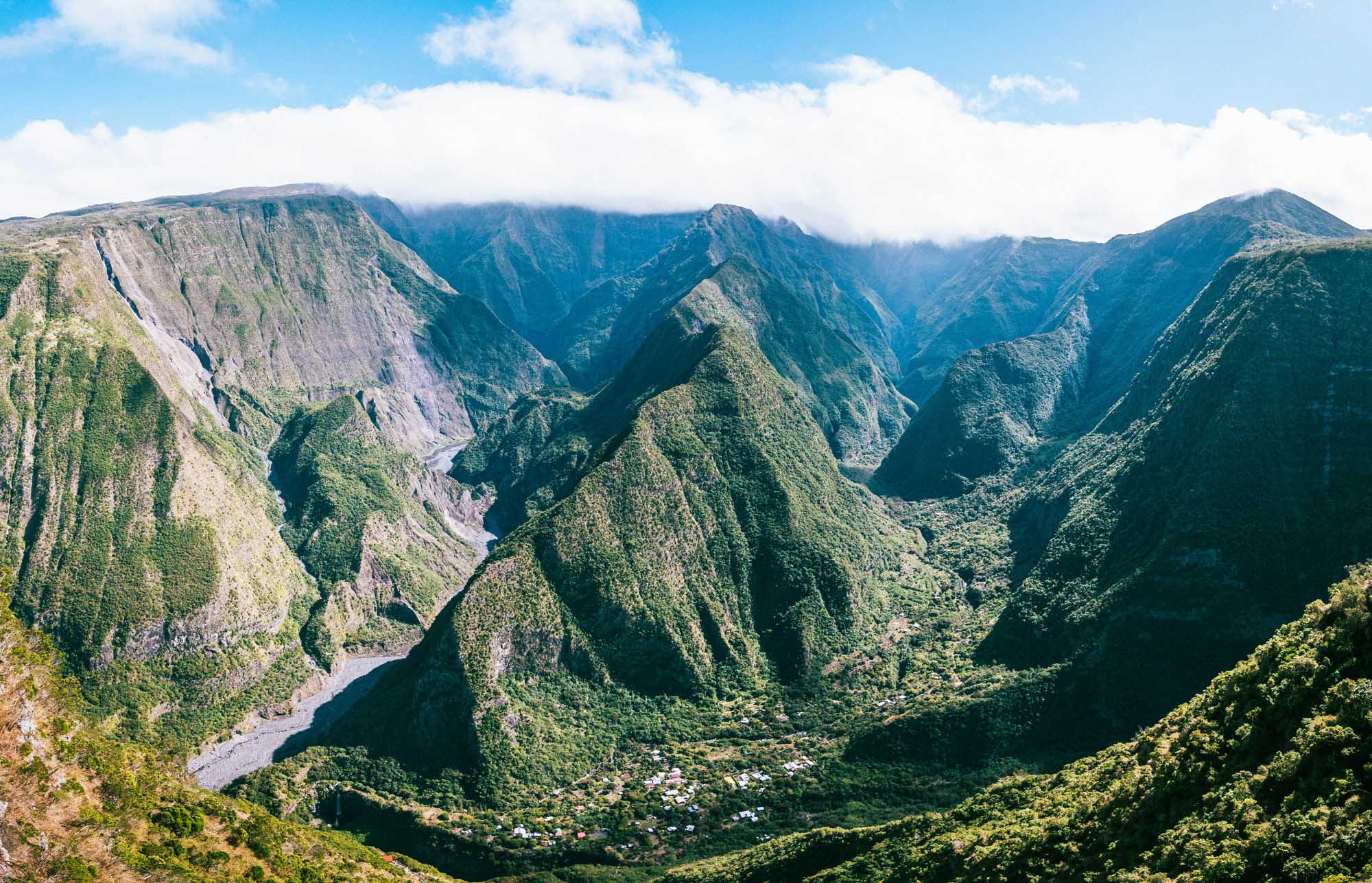 A breathtaking aerial view of a verdant valley carved by a winding river, surrounded by steep
