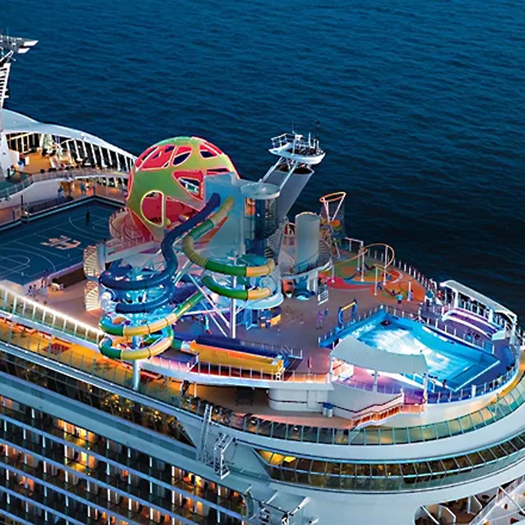 An aerial view of a modern cruise ship's lido deck featuring a vibrant, multi-colored waterslide