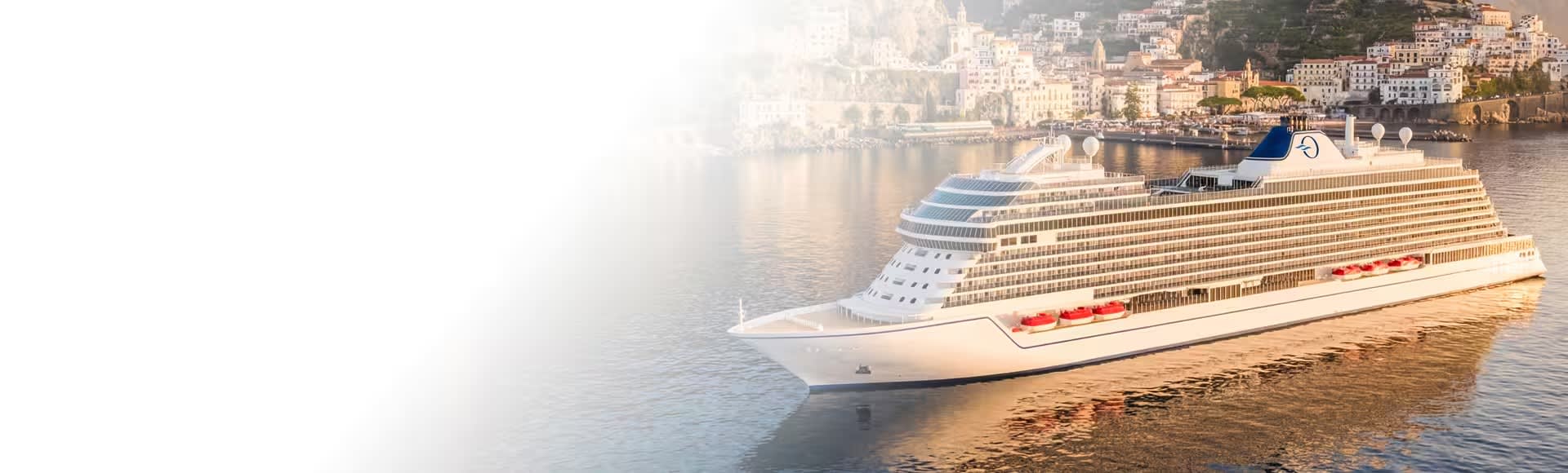 A modern luxury cruise ship from Oceania Cruises is anchored in calm Mediterranean waters near