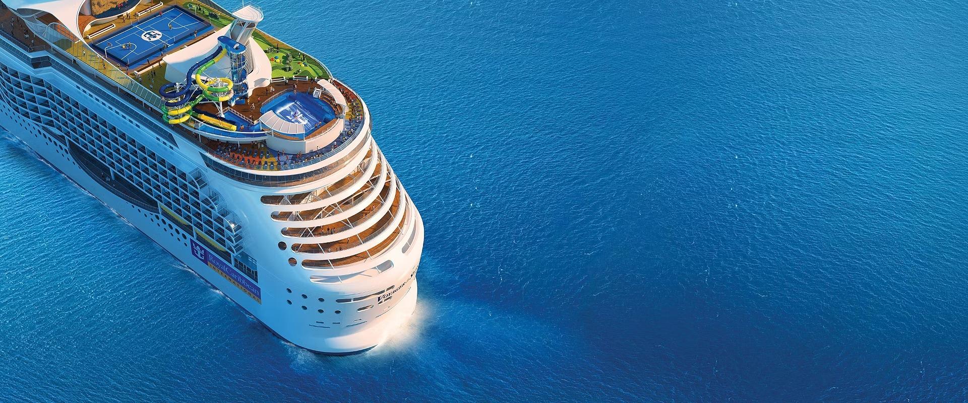 An aerial view of a modern large cruise ship with distinctive white hull and tiered balconies