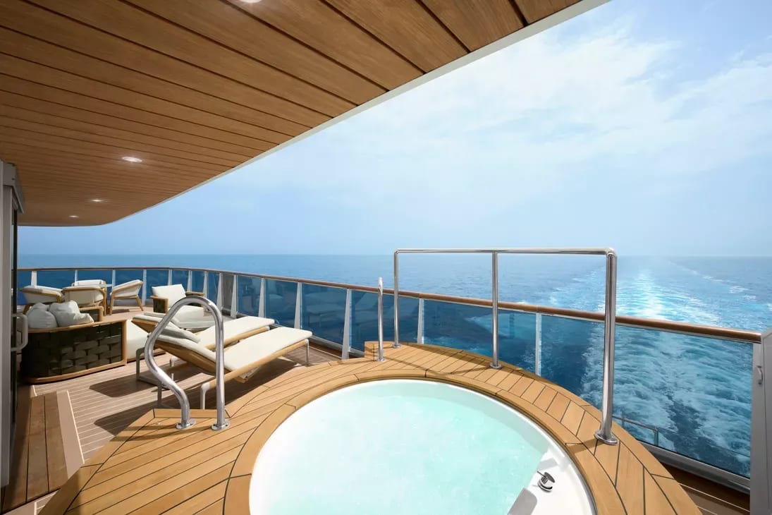 An expansive private balcony aboard a luxury cruise ship featuring a circular hot tub