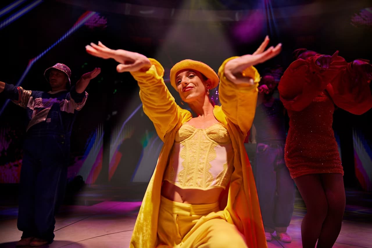 A vibrant theatrical performance aboard a Celebrity Cruises ship, featuring a lead performer in