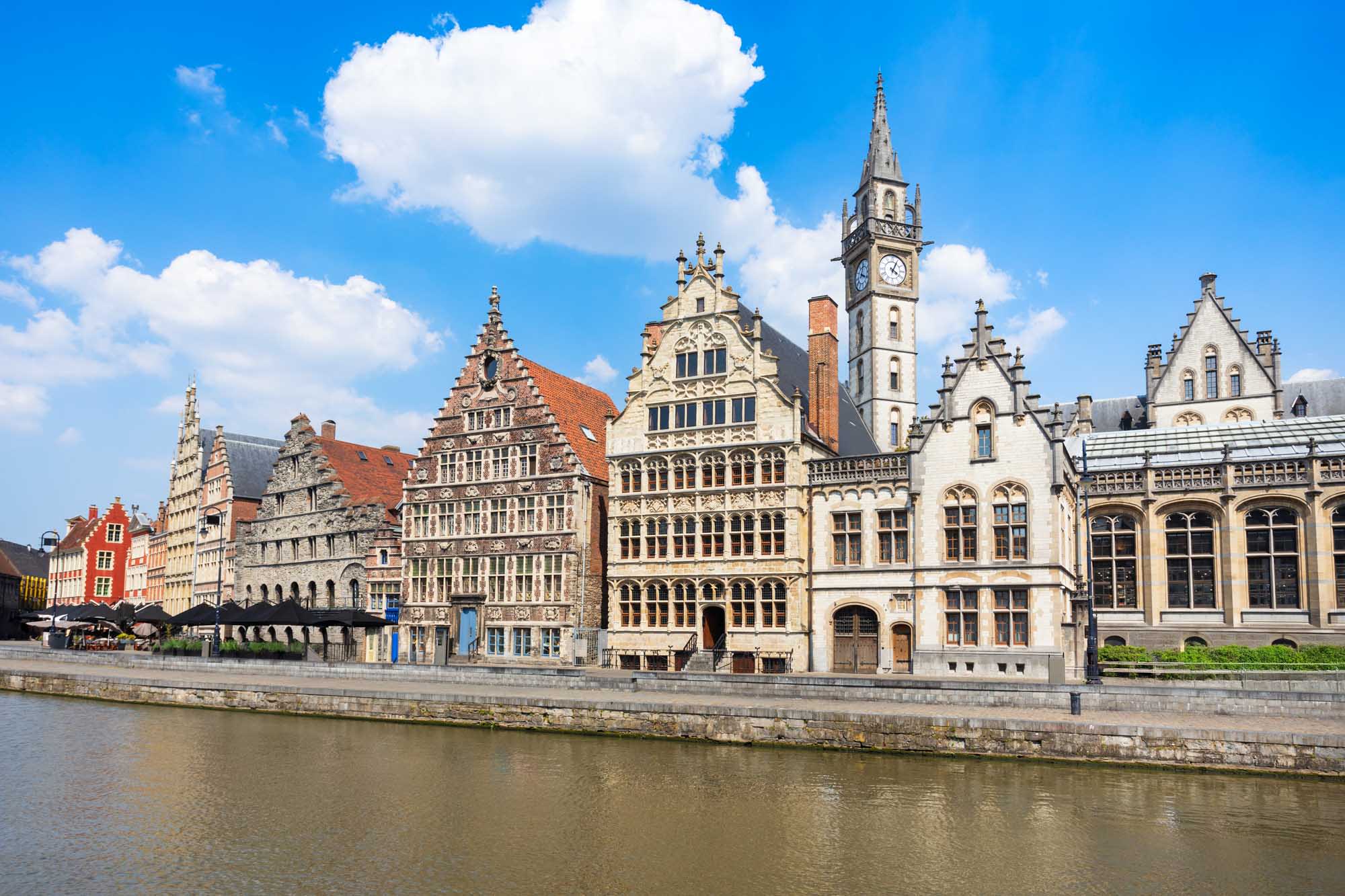 A picturesque waterfront view of historic Flemish guild houses lining the Graslei embankment along