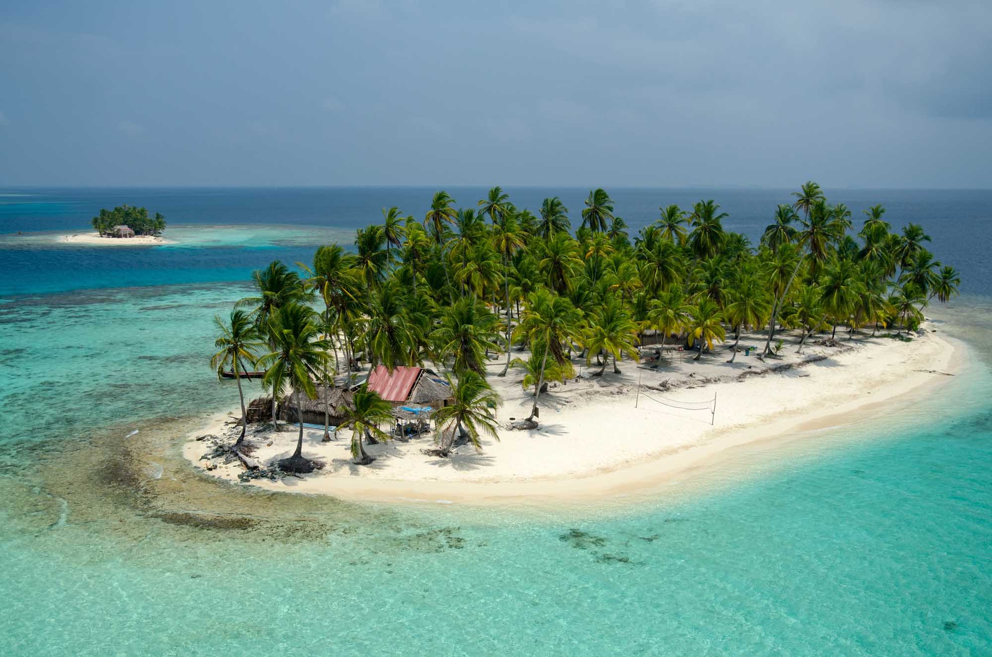 An aerial photograph of a pristine tropical island in the San Blas archipelago, Panama, featuring