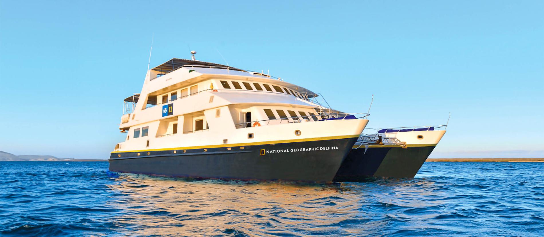 The National Geographic Delfina, a sophisticated expedition cruise vessel, anchors in crystalline