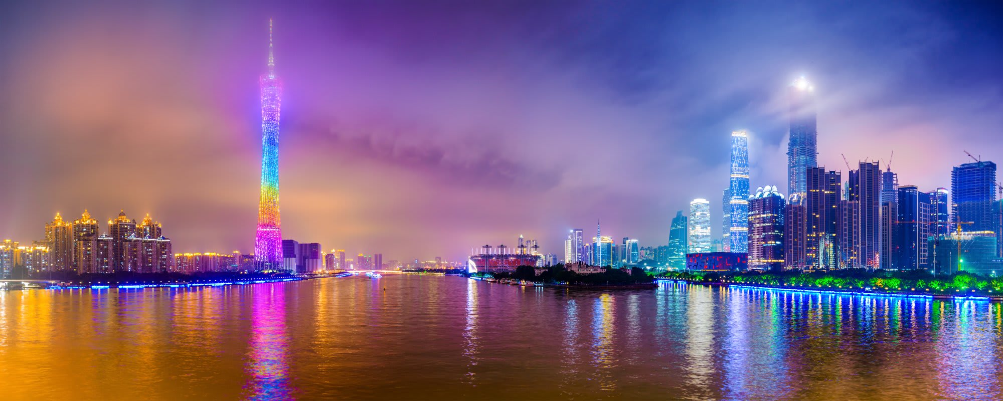 A stunning nighttime cityscape featuring a vibrant illuminated skyline with colorful lighting