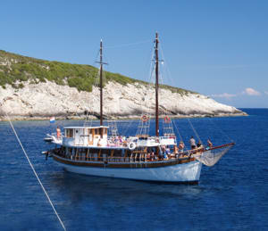 A classic wooden gulet sailing vessel anchored in crystal-clear turquoise Mediterranean waters