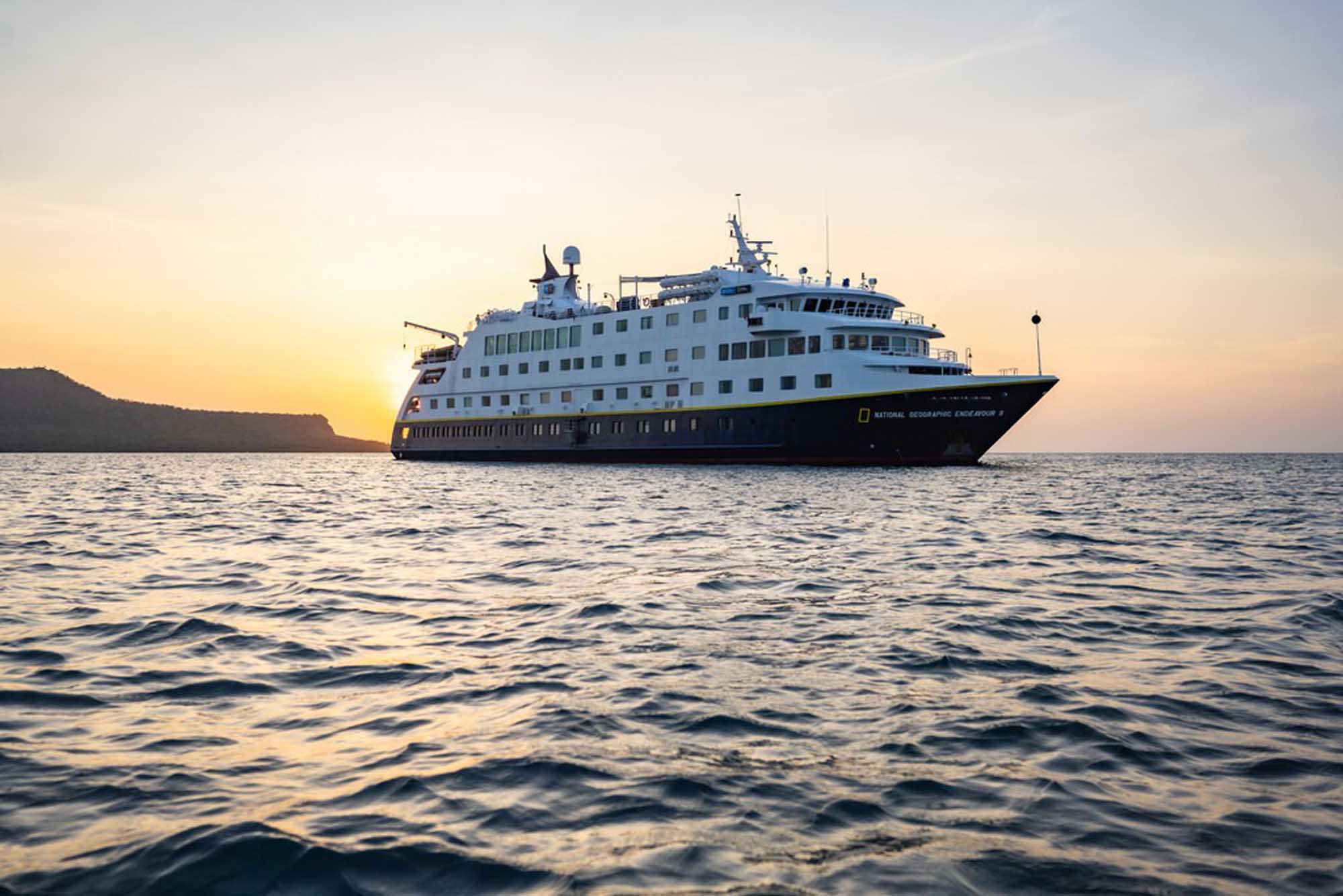 The National Geographic Endeavour II expedition cruise ship anchored offshore during golden hour
