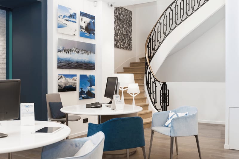 A contemporary office interior featuring a curved staircase, modern furnishings, and a curated
